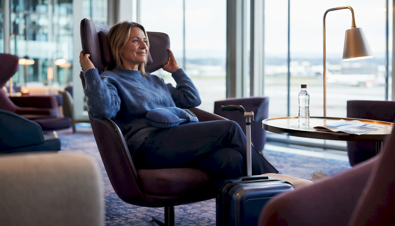 En passager sidder afslappet og nyder den ekstra plads og komfort i premium economy-klassen.
